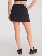 Falda deportiva negra con calza interior y bolsillo lateral. Diseño cruzado en la parte frontal.