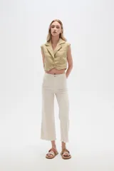 Pantalón jean blanco, recto y de calce alto con terminación desflecada.