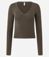 Suéter de punto color beige, con escote en V y mangas largas.