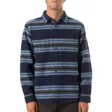 Camisa de franela a rayas horizontales en tonos azul marino, celeste y gris. Tiene cuello clásico, cierre frontal con botones, dos bolsillos de parche con botón en el pecho y mangas largas con puños abotonados.