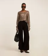 Blusa negra de punto liviano con escote redondo, manga larga y sisa raglán. Tiene una malla con lámina metálica.