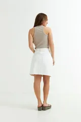 Minifalda blanca de jean con corte recto y ruedo desflecado.