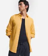 Camisa celeste de lino con cuello camisero, abotonadura frontal y mangas largas.