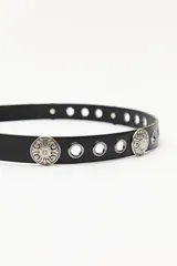 Cinturón negro con hebilla metálica plateada con diseño floral y apliques metálicos plateados con diseño floral.