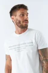 Remera blanca de algodón con cuello redondo y estampado frontal con texto en gris.