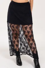 Pollera larga de encaje negro con diseño floral, con elástico en la cintura.