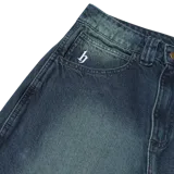 Jean baggy en denim de 12 oz, con doble proceso de lavado y teñido verdoso, tiro medio y fit suelto.