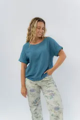 Remera básica de viscosa color azul petróleo, de corte recto y calce relajado, con escote redondo y mangas cortas con vuelta.