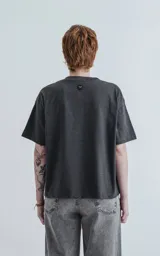 Remera manga corta gris oscuro, de cuello redondo y calce boxy fit.