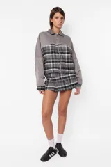 Campera gris con diseño a cuadros, de corte oversize, con cierre frontal y elástico en puños y cintura.
