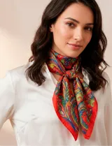 Pañuelo cuadrado de satén color rojo con estampado de arabescos en tonos azul, verde y amarillo.