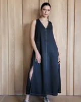 Vestido largo color crudo, sin mangas y con escote en V. Presenta aberturas laterales en el ruedo y bolsillos laterales a la altura de la cadera.