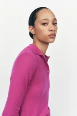 Jersey de lana color fucsia con cuello polo y tapeta con botones.
