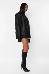 Campera de cuero sintético negro, corte oversize, cuello mao con broche, cierre metálico frontal, bolsillos con cierre, hombreras matelaseadas, puños con cierre y forro matelaseado.