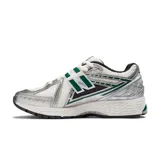 Championes New Balance modelo 1906R, color blanco con detalles en plateado y verde. Presentan el logo "N" en los laterales y tecnología de amortiguación N-ergy en la entresuela.