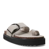 Sandalias planas color gris con hebilla metálica negra, tira ancha sobre el empeine y tira entre los dedos. Plataforma con base de corcho y suela de goma negra.