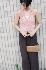 Top de escote pico y sin mangas, color rosa pálido. Tejido semitransparente con efecto arrugado y volantes delanteros. Cierre frontal con botones.