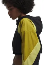 Campera deportiva corta negra con mangas amarillas y capucha. Confeccionada en tejido ligero con textura arrugada.