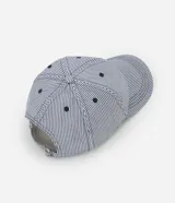 Gorra de béisbol con rayas verticales azules y blancas, bordado de ondas en el frente y visera curva.