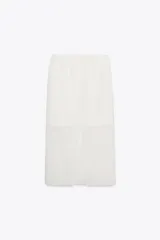 Falda midi color blanco, semitransparente, de tiro medio con cintura elástica, forro corto interior y abertura en la espalda.