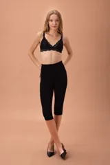 Soutien de forma triangular confeccionado en terciopelo negro con detalles de encaje en los bordes y la base. Cuenta con tirantes finos y ajustables.