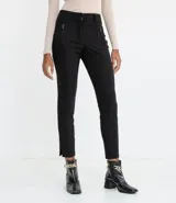 Pantalón skinny negro de la marca Cortelle, con cierre frontal y bolsillos laterales con cremallera. Presenta aberturas pequeñas en los tobillos.