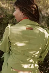 Camisa marrón con lunares blancos, corte clásico, cuello camisero, mangas 3/4 abullonadas y lazo ajustable en la cintura.