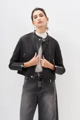Campera negra de cuero ovino con cierre frontal asimétrico, cuello mao con botón a presión y bolsillos con cierre.
