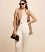Pantalón zanahoria de sastrería color blanco, con cintura alta, trabillas y botón contrastante.