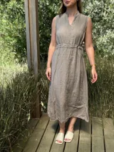 Vestido marrón de lino, corte midi, sin mangas, con cuello mao y cintura elastizada.