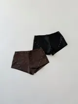 Short de cuero sintético color marrón con tachas plateadas en los laterales.