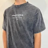 Remera gris con efecto lavado, corte oversize y estampado en la espalda con texto y dibujo de una caracola.