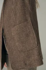 Chaleco color beige, entallado, con solapa, bolsillos plaqué y terminaciones envivadas.