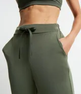 Pantalón jogger deportivo color verde militar, con cintura elástica ajustable con cordón, bolsillos laterales y puños elásticos.