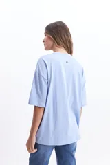 Remera blanca de corte amplio con estampado de tres rodajas de naranja y pomelo en tonos naranja y rosa.