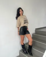 Short negro de cuero sintético con tachas plateadas en los bordes.