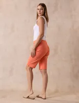 Bermuda color beige en gabardina elastizada, con pretina ancha elastizada, bolsillos simulados en la parte delantera y bolsillos aplicados en la parte trasera.