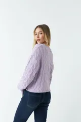 Sweater tejido con trama de ochos color fucsia, cuello redondo y corte cropped.