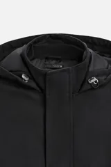 Parka negra de corte regular, confeccionada en tejido técnico acolchado. Tiene cuello alto con capucha ajustable, mangas largas con puños ajustables, bolsillos con solapa en la cadera y un bolsillo interior. El cierre frontal es con cremallera oculta por solapa con botones a presión.