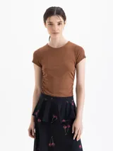 Remera de manga corta y escote redondo confeccionada en tejido morley de punto, con frunces en los laterales.