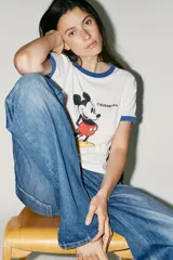 Camiseta blanca de algodón con cuello redondo y mangas cortas con ribete azul. Estampado frontal de Mickey Mouse y texto 'California'.