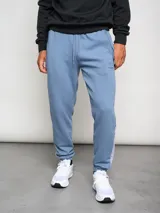 Pantalón de jogging celeste con puños ajustados, cortes laterales y detalles en gris.