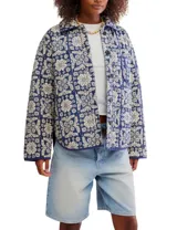 Chaqueta acolchada con estampado floral en tonos azul y beige, cuello camisero y cierre frontal con botones.