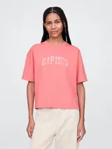 Remera corta color blanco con logo de Gap estampado en el frente y mangas cortas con detalle de rayas horizontales.