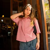 Camisa de hombre de corte boxy fit, con estampado de rayas verticales en tonos grises y blancos, confeccionada en gabardina de algodón. Presenta cuello clásico, mangas cortas y bordado con el logo de la marca en la espalda.