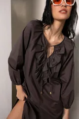 Vestido largo color marrón con tajos laterales, escote con volados y lazos con punteras metálicas.