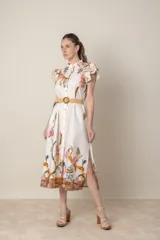 Vestido midi camisero de algodón color natural con estampado de flores, animales y ramas en tonos rojo, marrón, verde y azul. Tiene cuello mao, mangas cortas con volados, bolsillos laterales y cinturón de soga color beige.