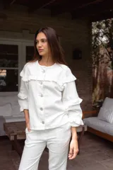 Campera de jean blanca con volados en el frente y las mangas, confeccionada en algodón y lino.