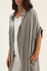 Vestido camisero largo color gris, de seda lisa, con cuello camisero, manga corta y cierre frontal con botones.