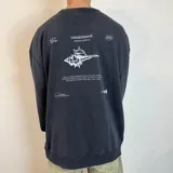 Buzo negro de corte oversize con estampa en la espalda que incluye un caracol, texto y los logos "Underwave" y "SND".
